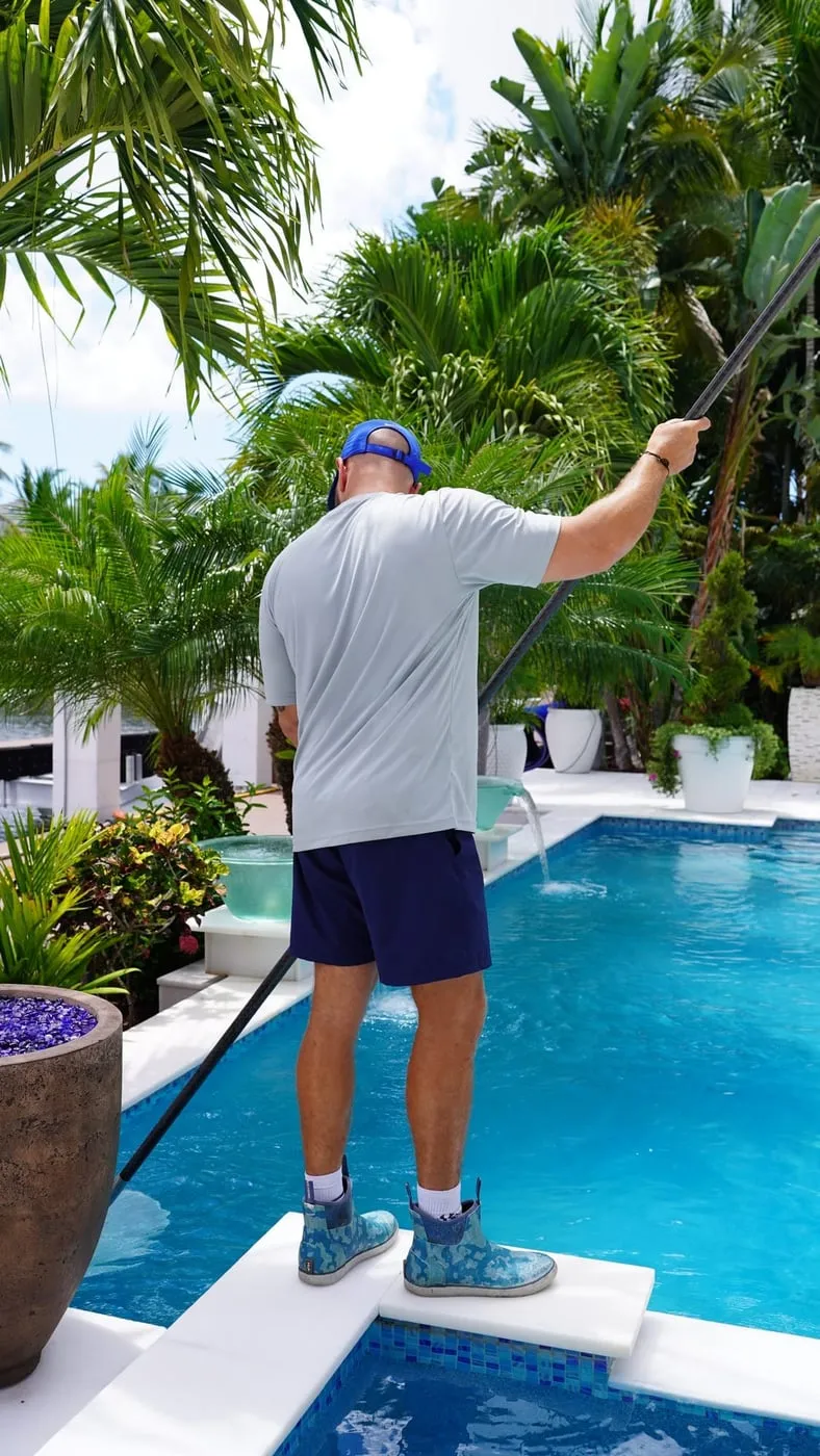 Technician skimming a pool